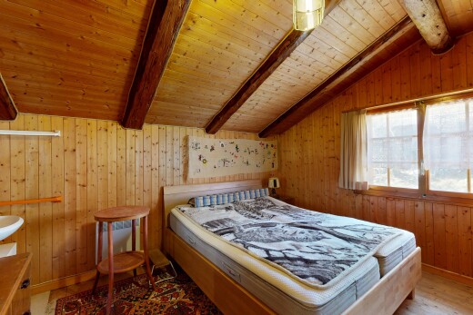 chambre avec beamed ceiling, plafond à poutres, wood wall, mur en bois, et inside property