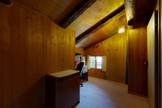 couloir avec plafond à poutres, beamed ceiling, mur en bois, wood wall, et moquette