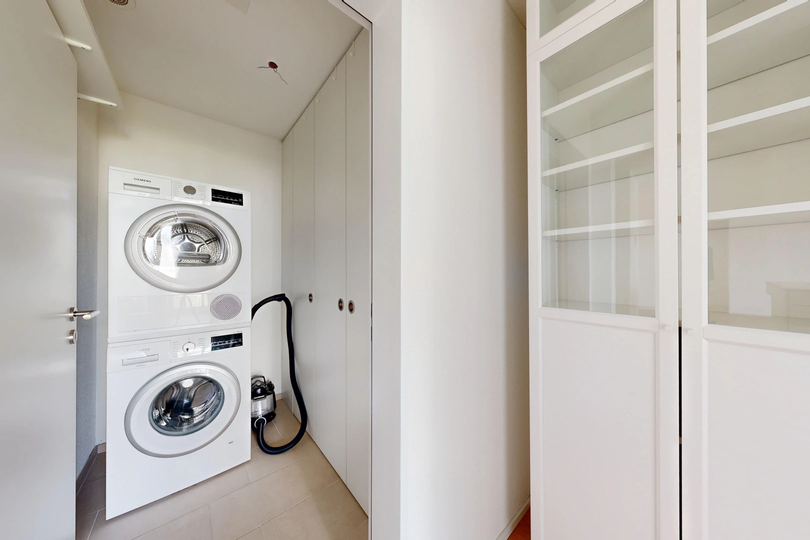 buanderie avec light floor, lave-linge et sèche-linge superposés, inside property, cloison sèche, et drywall