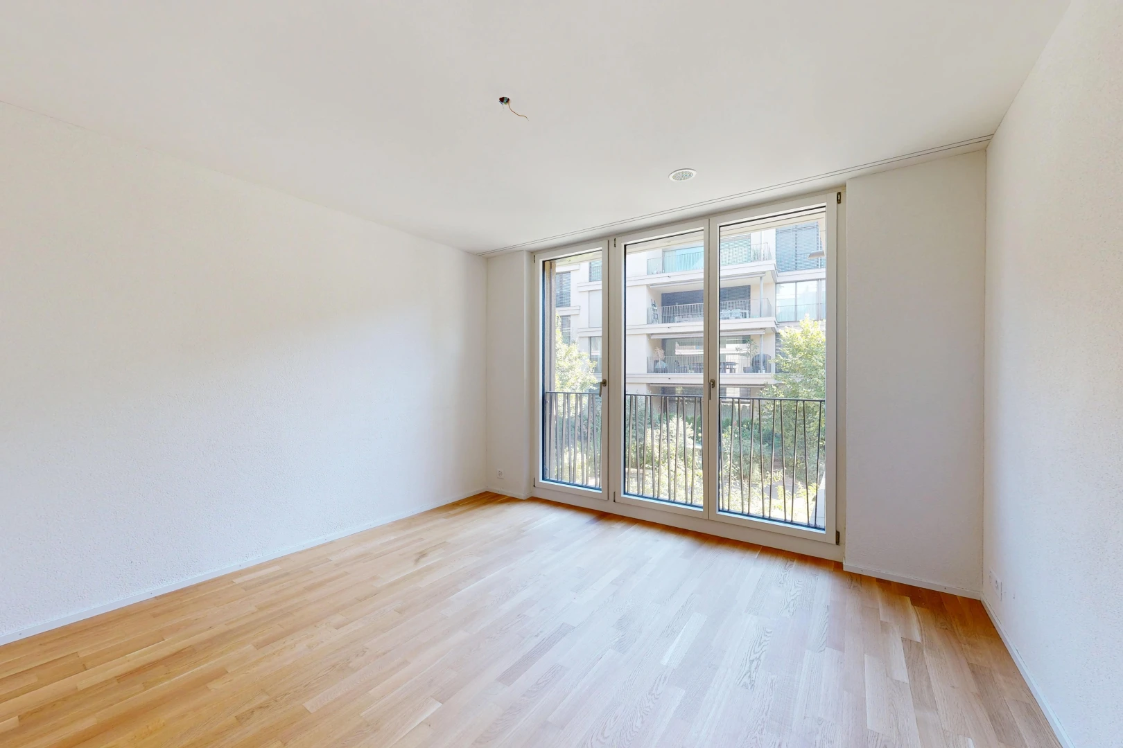 pièce vide avec inside property, cloison sèche, drywall, sol en finition bois, et wood finish floor