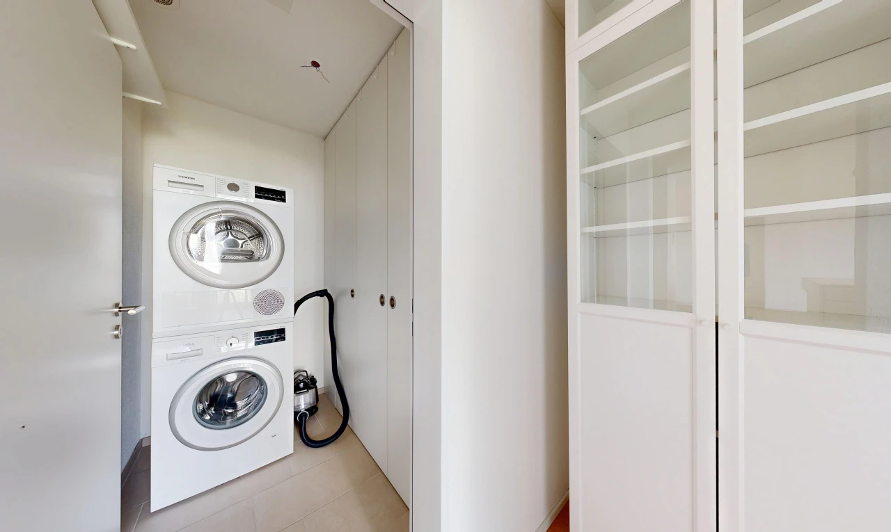 buanderie avec light floor, lave-linge et sèche-linge superposés, inside property, cloison sèche, et drywall