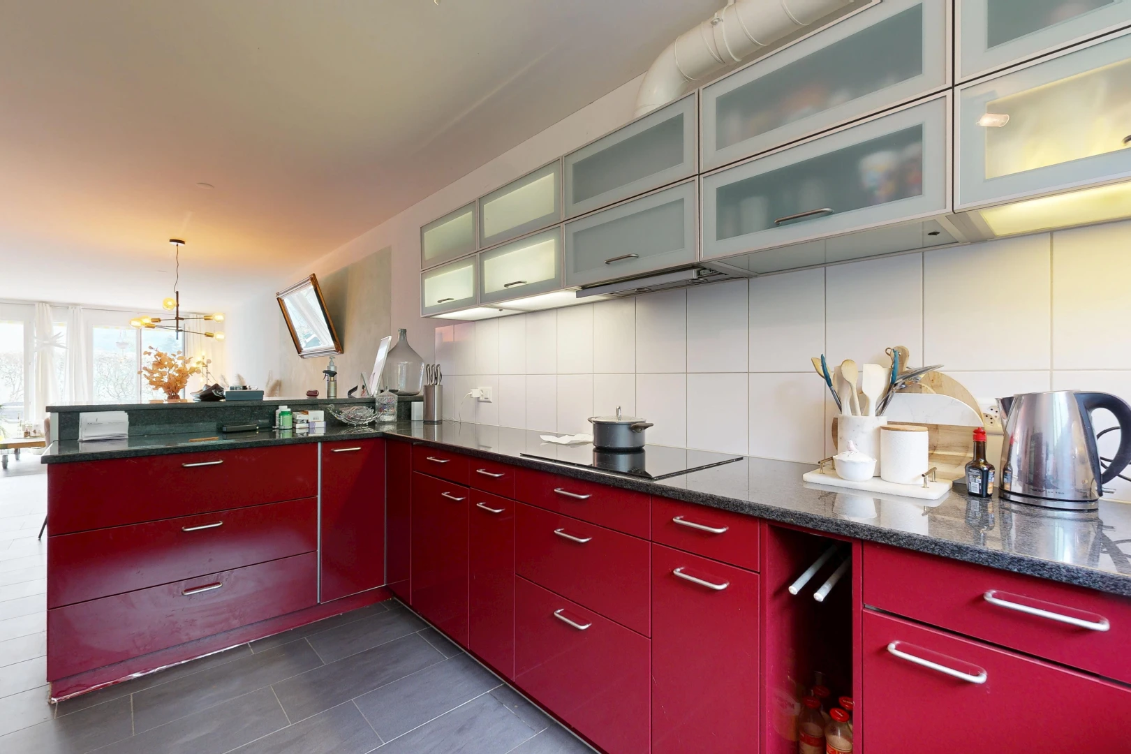 kitchen featuring glass insert cabinets, black electric cooktop, dark stone countertops, and tasteful backsplash