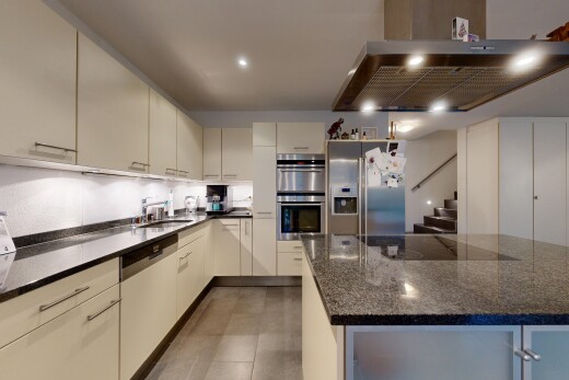 küche mit dunstabzugshaube, cremefarbene schränke, kühlschrank, inside property, und doppel backofen