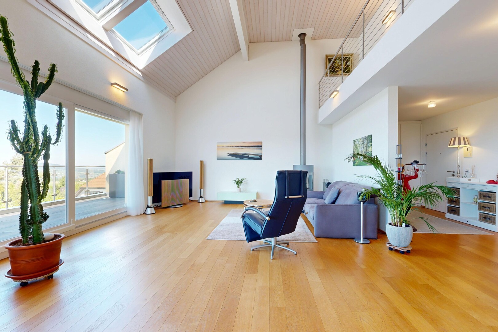 salon avec day time, high ceiling, plafond haut, wood finish floor, et sol en finition bois