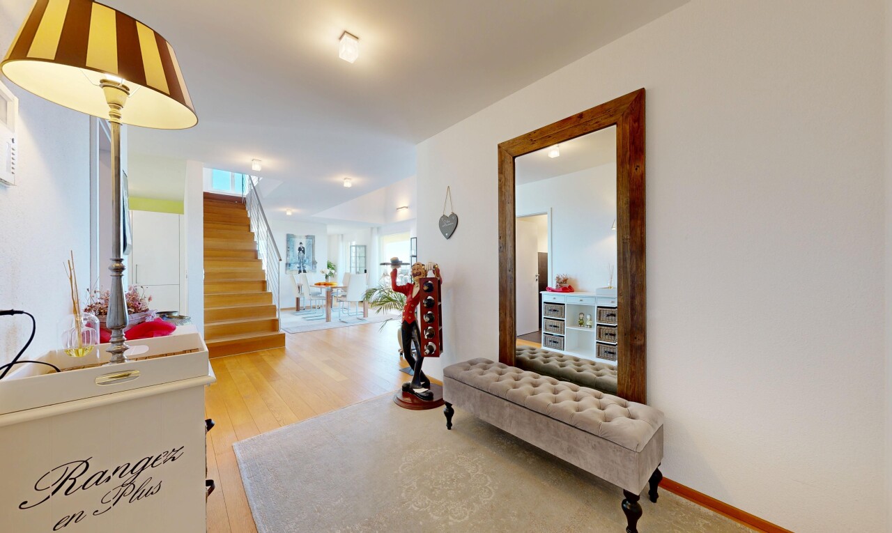 couloir avec escaliers, wood finish floor, sol en finition bois, drywall, et cloison sèche