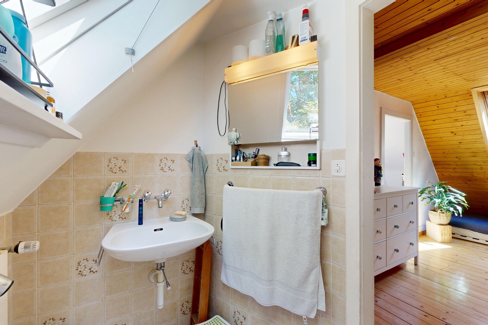 bathroom featuring tile walls, wood ceiling, vaulted ceiling with skylight, and light wood-style flooring