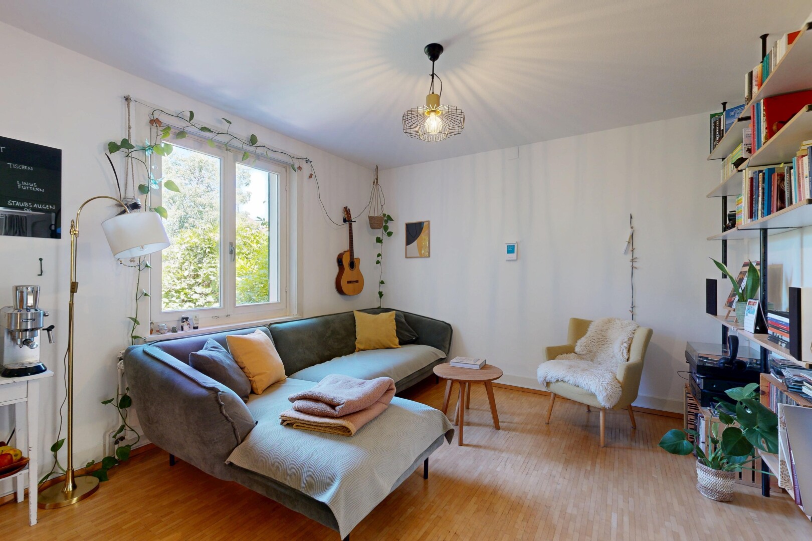 living area with light wood-style floors and decorative light fixtures