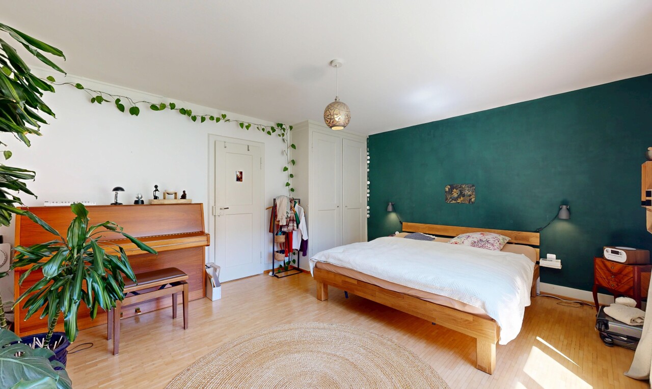 room / bedroom featuring light wood-style floors, hanging light fixtures, and a closet