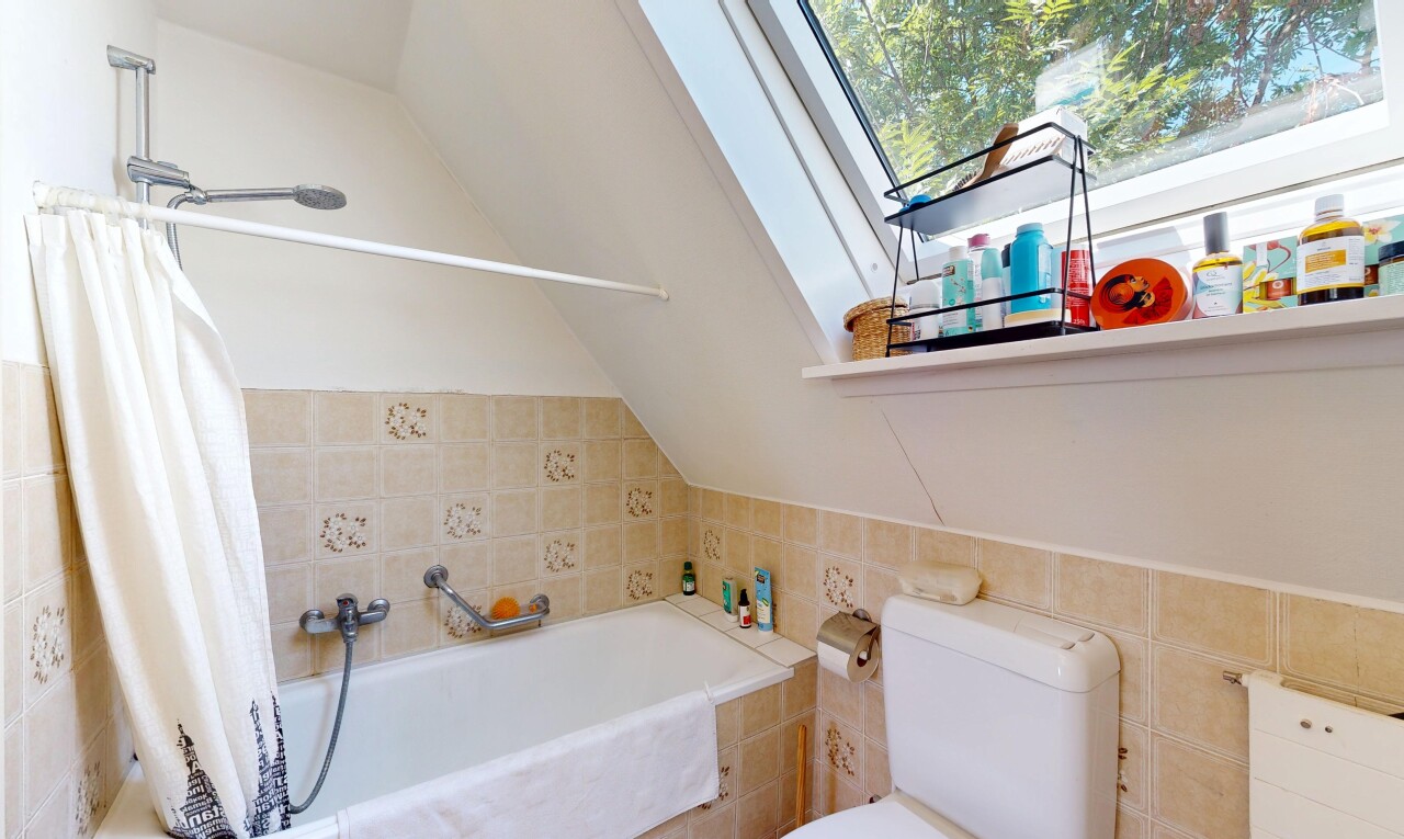 bathroom featuring tile walls, lofted ceiling, and tiled shower / bath