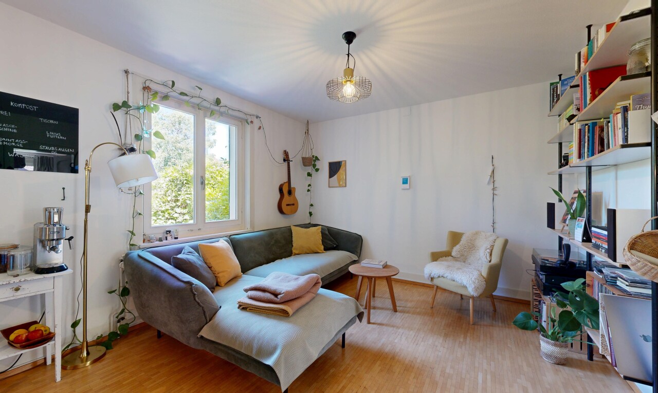 living area with light wood-style floors and decorative light fixtures