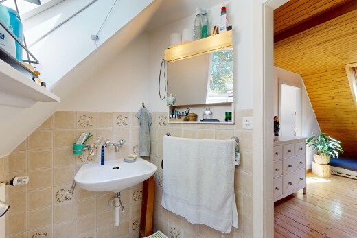 bathroom featuring tile walls, wood ceiling, vaulted ceiling with skylight, and light wood-style flooring