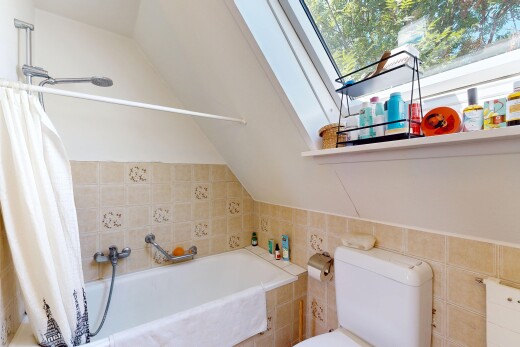 bathroom featuring tile walls, lofted ceiling, and tiled shower / bath