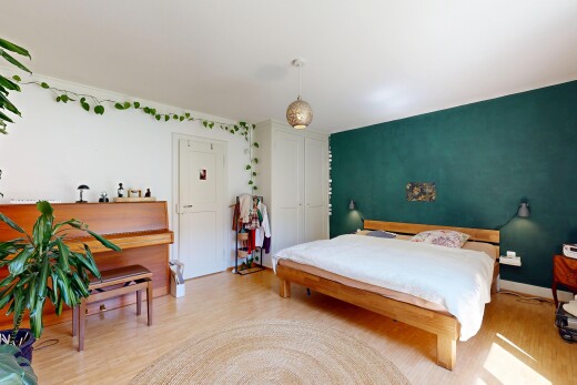 room / bedroom featuring light wood-style floors, hanging light fixtures, and a closet