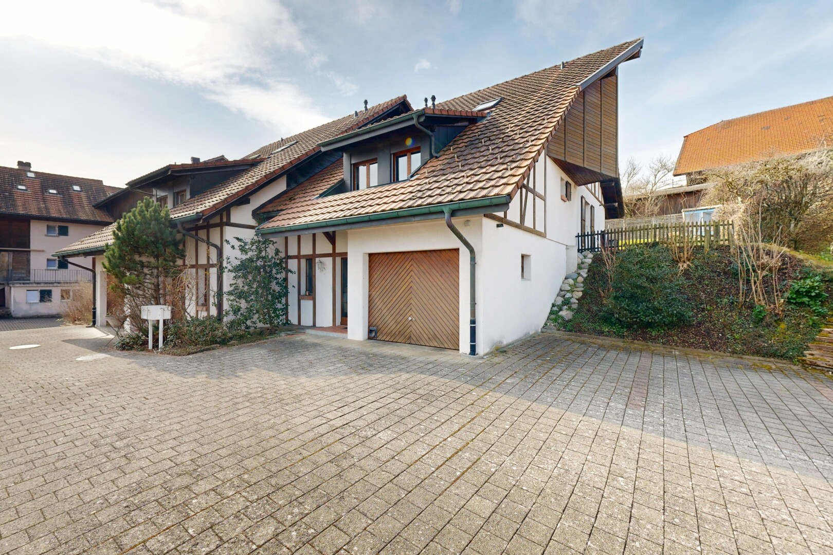 außenansicht mit day time, auffahrt, property visible, stuckverkleidung, und garage angeschlossen