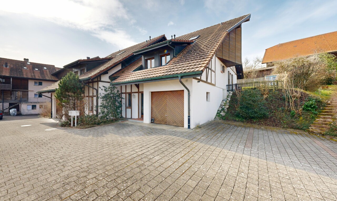 außenansicht mit day time, auffahrt, property visible, stuckverkleidung, und garage angeschlossen