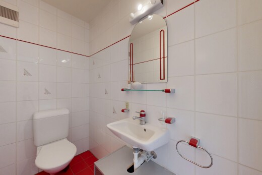 salle de bains avec tile wall, mur en carrelage, miroir, toilette, et inside property