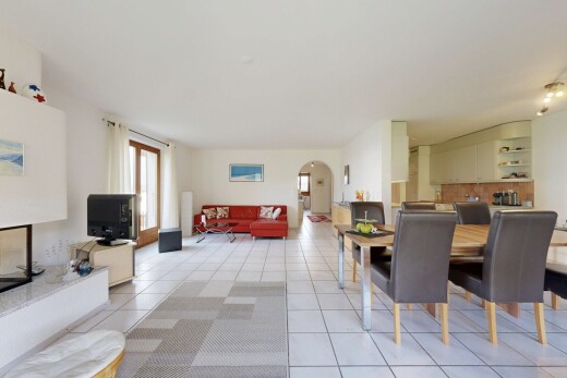 salon / salle à manger avec passages en arc, inside community, drywall, cloison sèche, et natural light