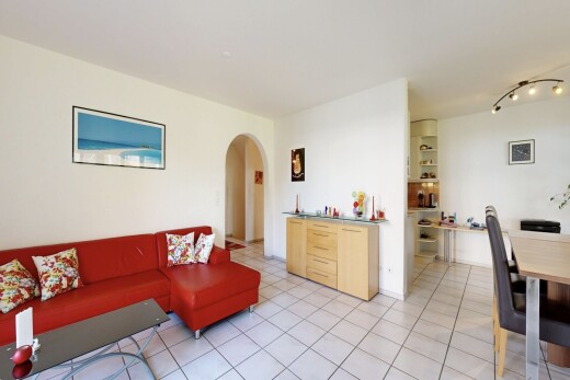 salon / salle à manger avec passages en arc, cloison sèche, drywall, inside property, et light floor