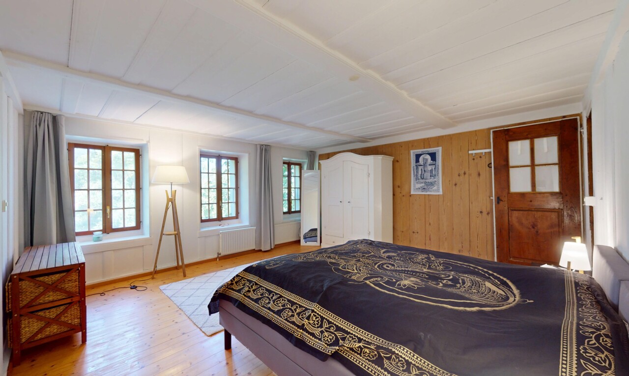 chambre avec wood finish floor, sol en finition bois, wood wall, mur en bois, et inside property