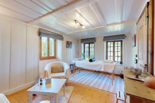 room with hardwood / wood-style floors, multiple windows, radiator, and a decorative wall