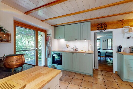 küche mit arbeitsfläche, schranktüren mit vertiefter mittelplatte, grüne schränke, inside property, und balkendecke