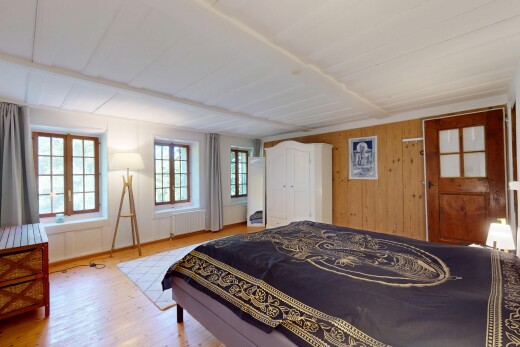 room / bedroom featuring wood finished floors, wooden walls, and radiator