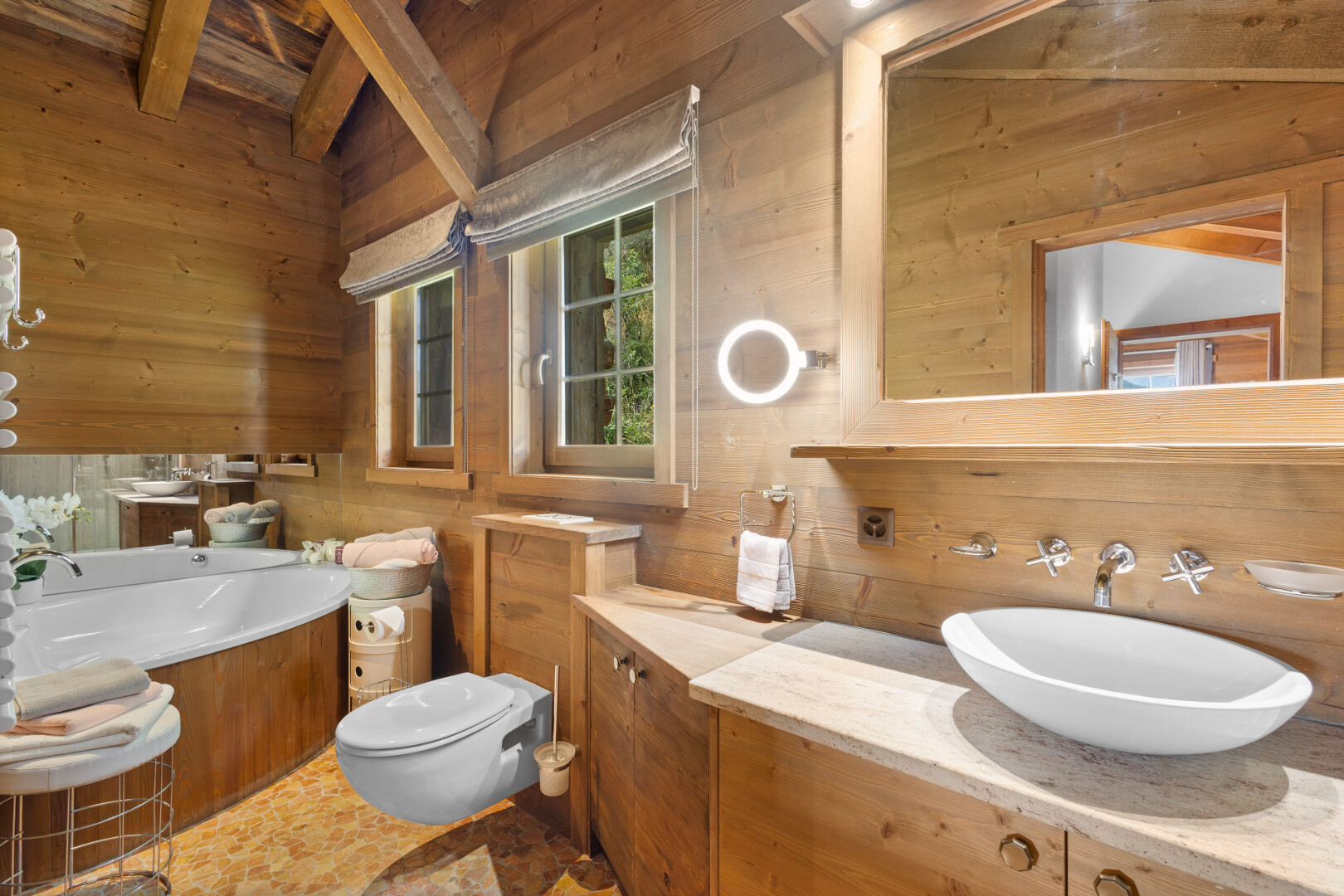 salle de bains avec mur en bois, wood wall, miroir, plafond à poutres, et beamed ceiling
