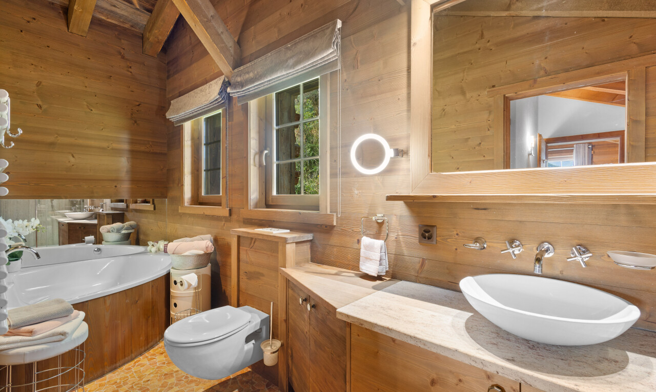 salle de bains avec mur en bois, wood wall, miroir, plafond à poutres, et beamed ceiling