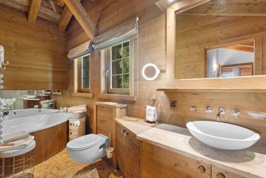salle de bains avec mur en bois, wood wall, miroir, plafond à poutres, et beamed ceiling