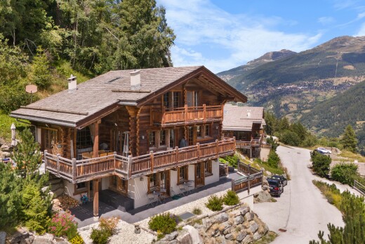 façade avec property visible, mountain view, vue sur la montagne, cheminée, et balcon