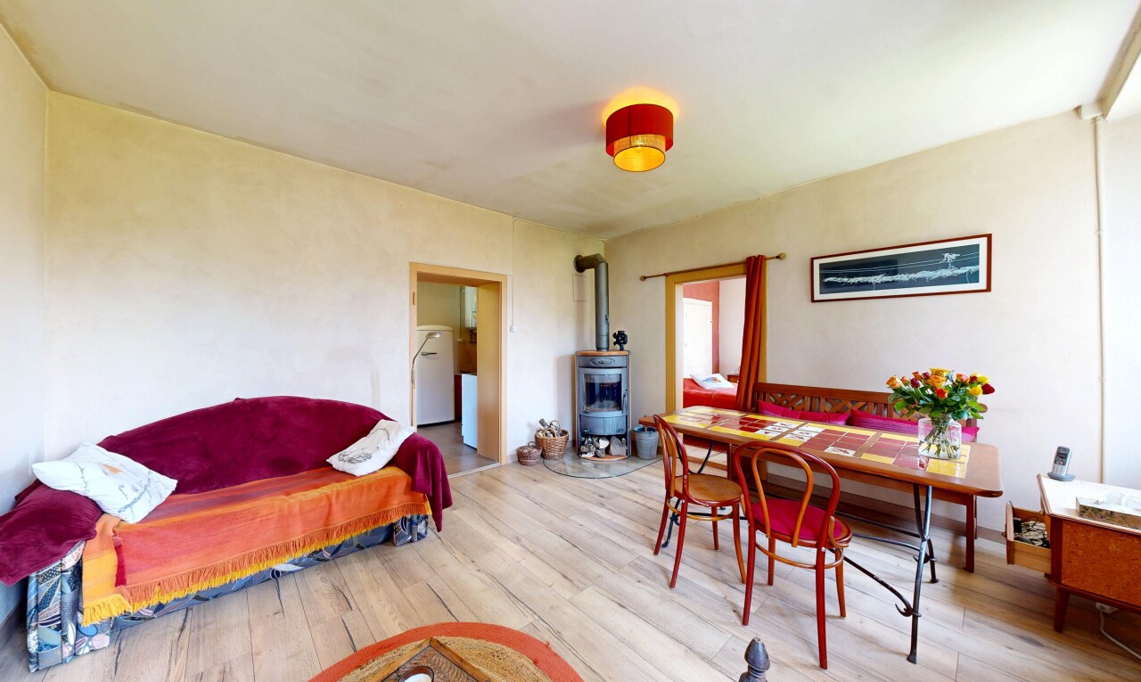 salon / salle à manger avec poêle à bois, sol en finition bois, wood finish floor, inside property, et cloison sèche
