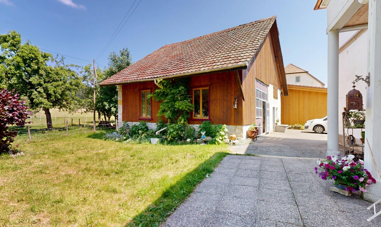façade avec bardage vertical, property visible, pelouse, bardage en bois, et day time