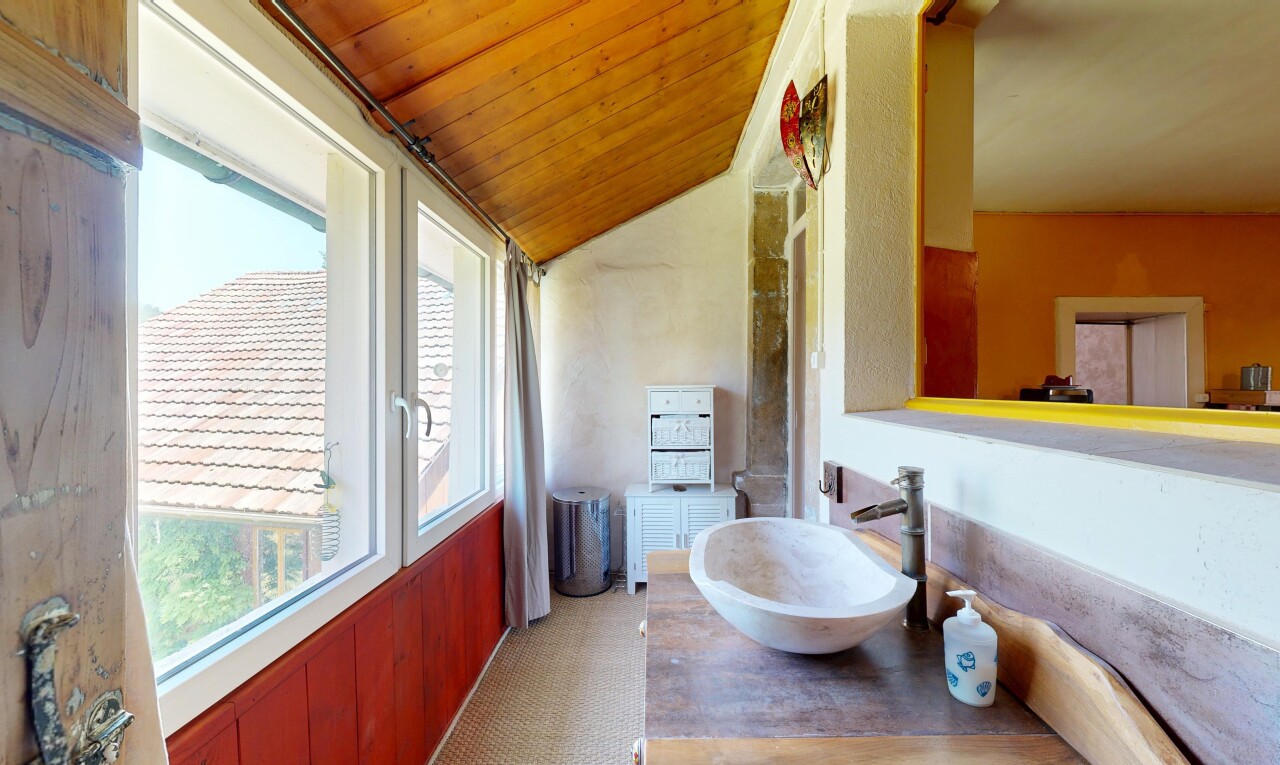 salle de bains avec natural light, lumière naturelle, évier, vaulted ceiling, et plafond voûté