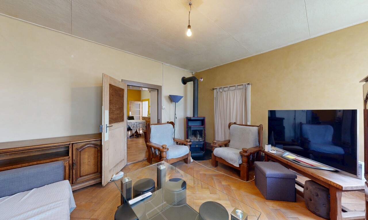 salon / salle à manger avec télévision, poêle à bois, cloison sèche, drywall, et inside property