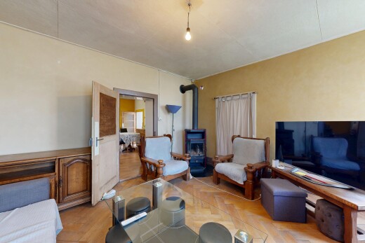 wohn- / esszimmer mit fernseher, holzofen, gipskartonwand, drywall, und inside property