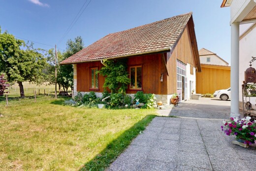 façade avec bardage vertical, property visible, pelouse, bardage en bois, et day time
