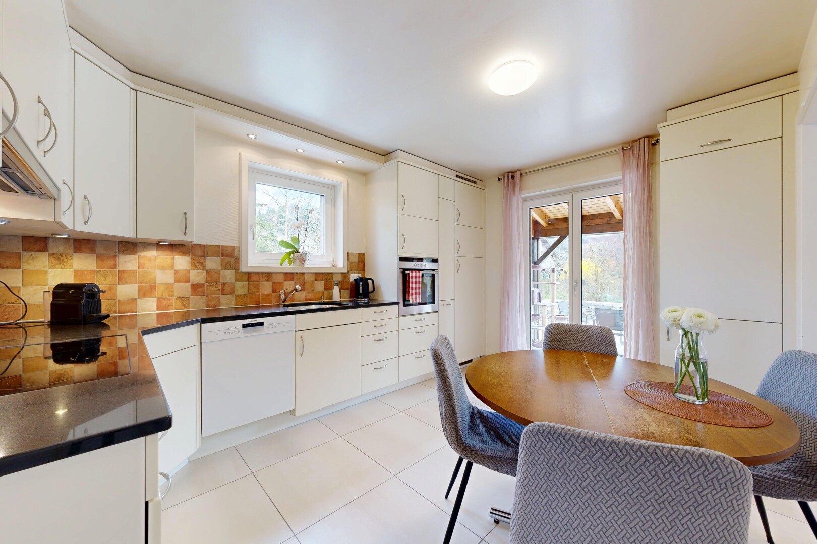 cuisine avec light floor, lave-vaisselle, dark countertops, plans de travail, et white cabinets