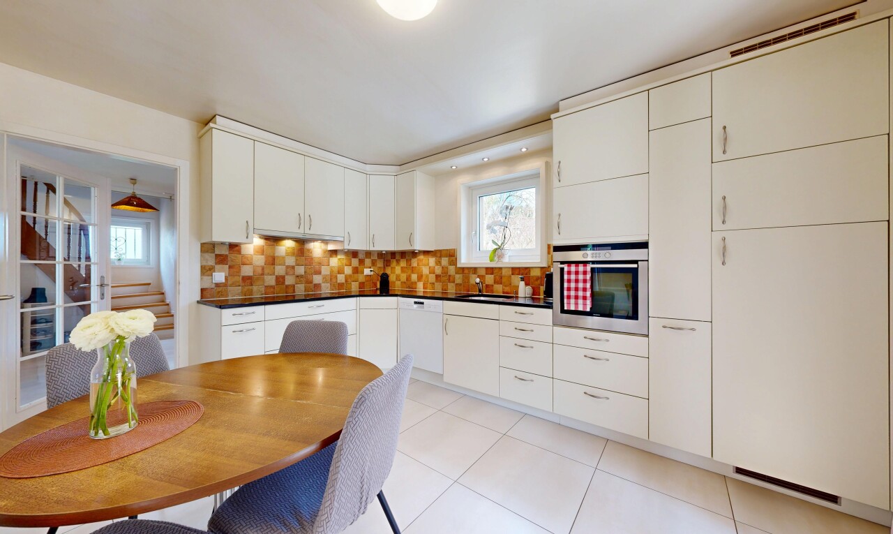 cuisine avec four, plans de travail, dark countertops, light floor, et lumière naturelle