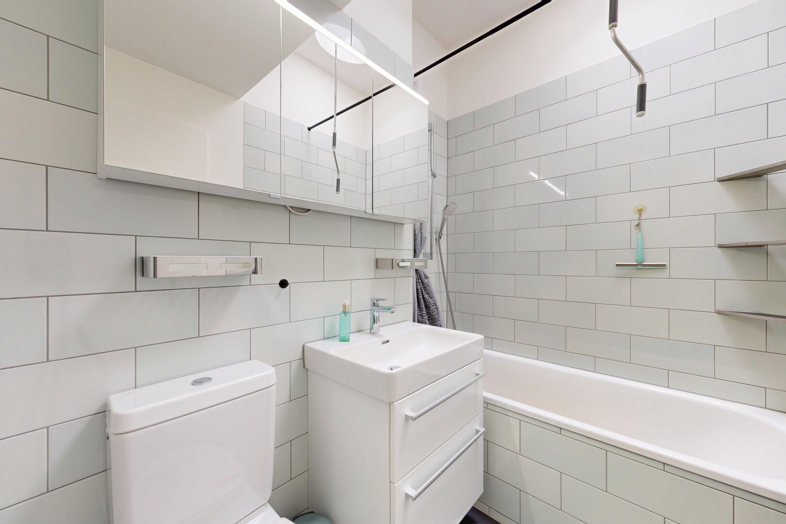 salle de bains avec miroir, lavabo (ou coiffeuse selon le contexte), salle de bain complète, toilette, et douche-bain combinés