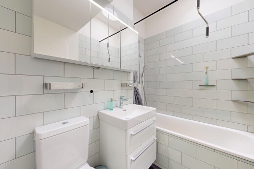 salle de bains avec miroir, lavabo (ou coiffeuse selon le contexte), salle de bain complète, toilette, et douche-bain combinés