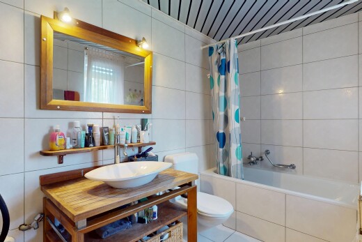 salle de bains avec évier, toilette, miroir, tile shower, et inside property