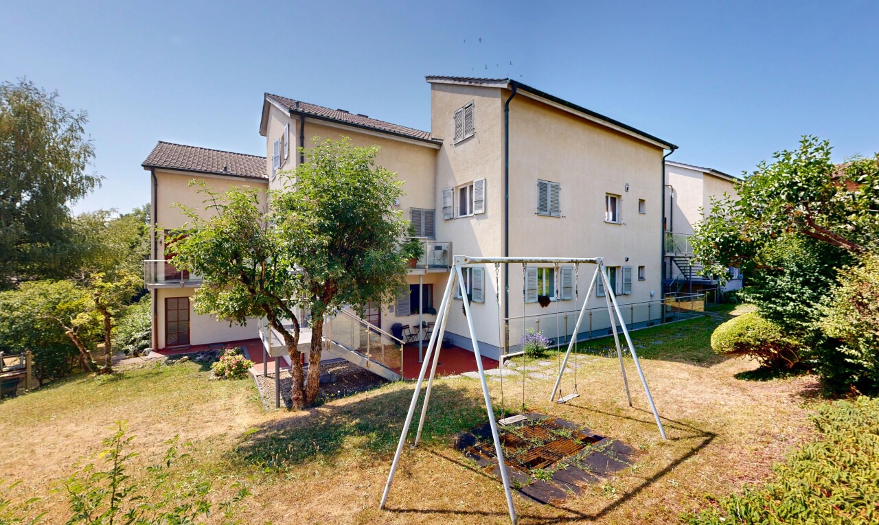 façade avec pelouse, property visible, escaliers, aire de jeux, et day time