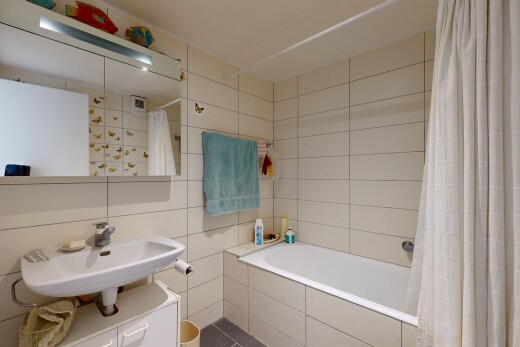 salle de bains avec mur en carrelage, tile wall, salle de bain complète, inside property, et évier