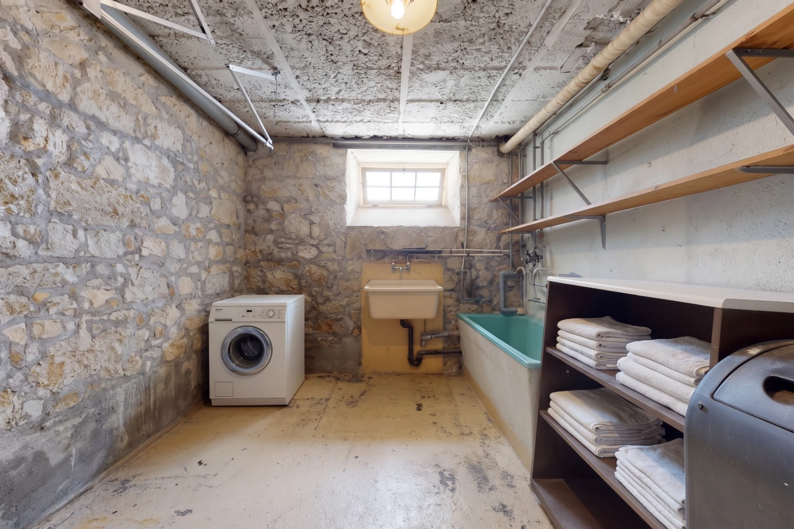 buanderie avec lave-linge et sèche-linge, sous-sol, lumière naturelle, évier, et inside property