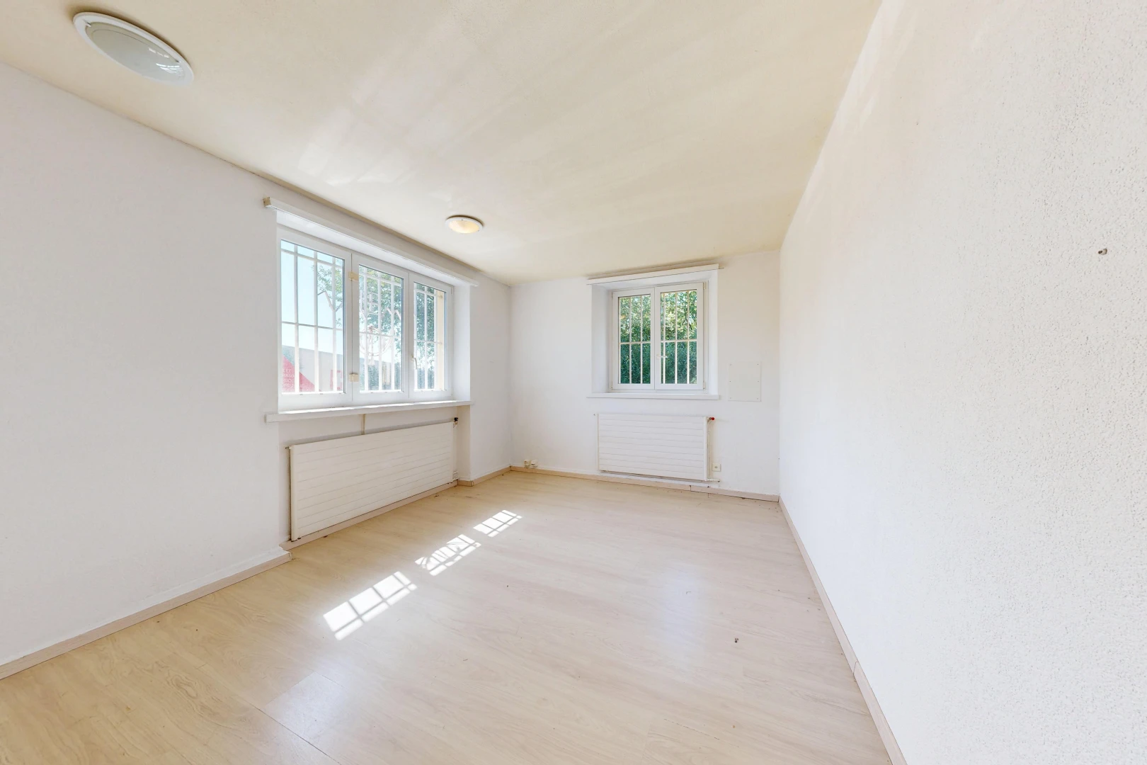 pièce vide avec radiateur, lumière naturelle, wood finish floor, sol en finition bois, et baseboards wall