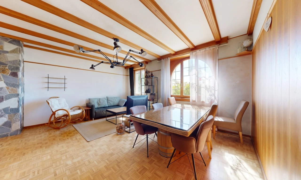 salon / salle à manger avec beamed ceiling, plafond à poutres, parquet floor, wood finish floor, et sol en finition bois
