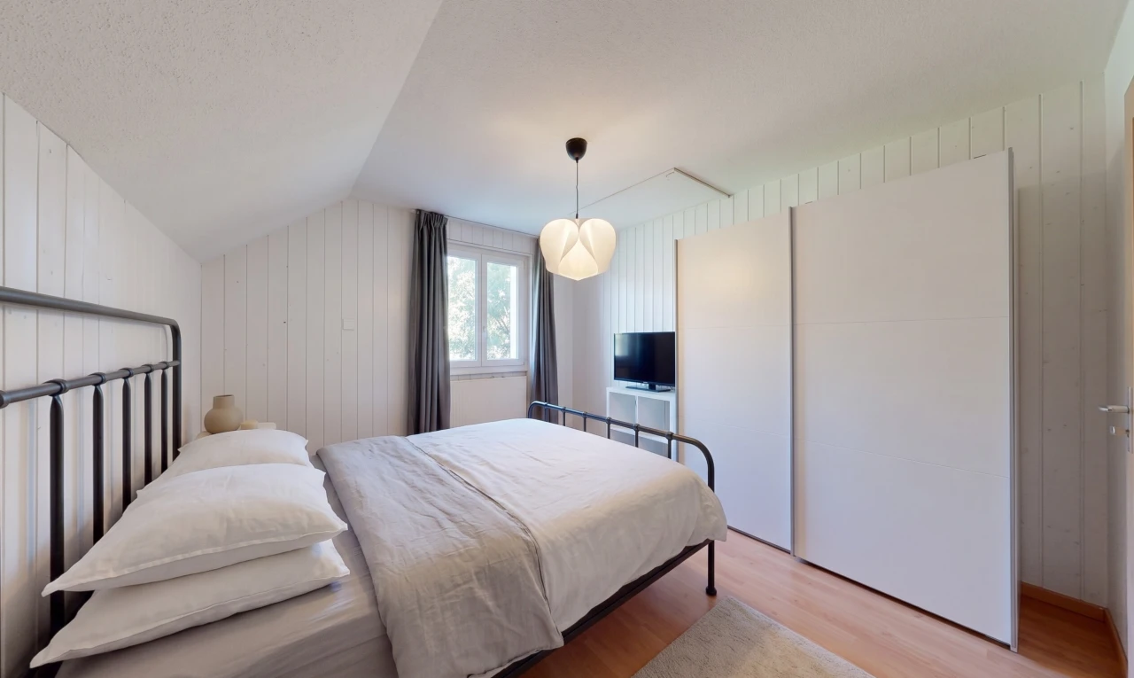 chambre avec vaulted ceiling, plafond voûté, wood finish floor, sol en finition bois, et wood wall