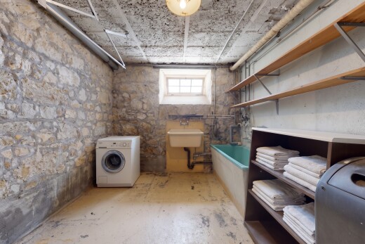 buanderie avec lave-linge et sèche-linge, sous-sol, lumière naturelle, évier, et inside property