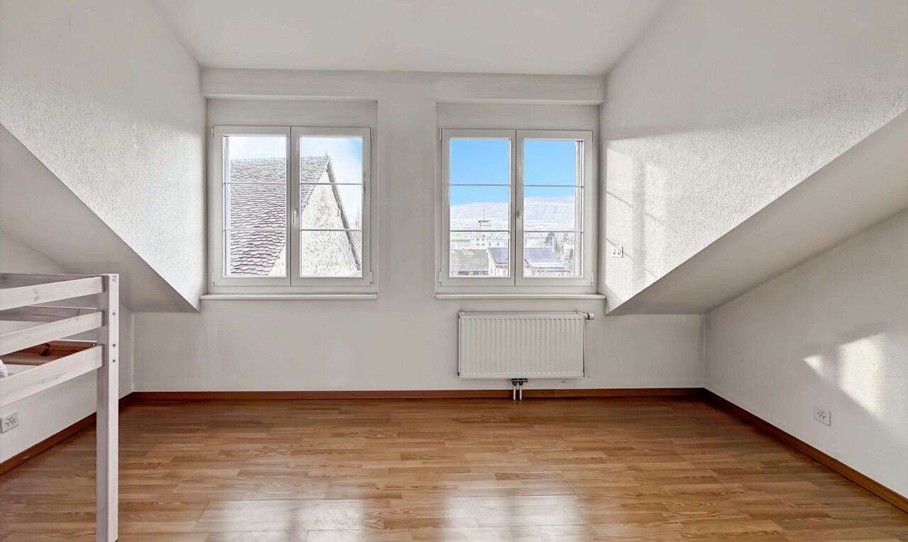 pièce vide avec vaulted ceiling, plafond voûté, radiateur, wood finish floor, et sol en finition bois