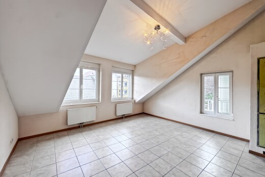 pièce vide avec plafond voûté, vaulted ceiling, plafond à poutres, beamed ceiling, et radiateur